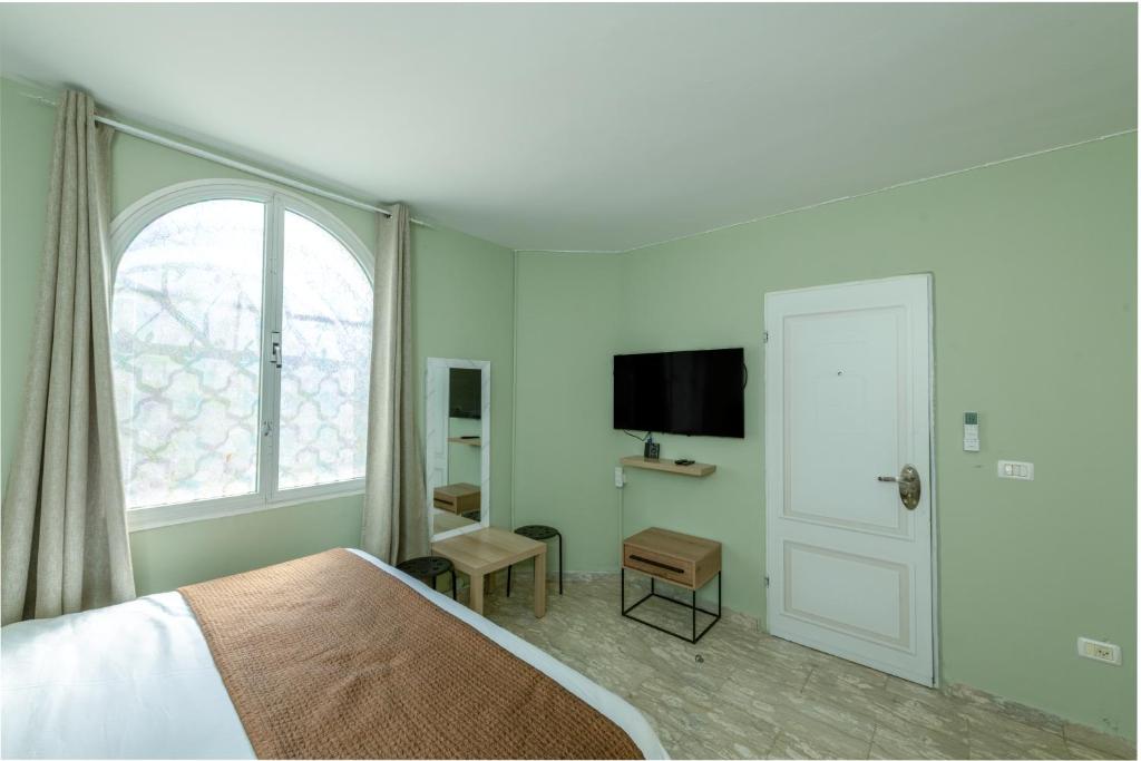 a bedroom with a bed and a window and a television at Villa Li Eilat in Eilat