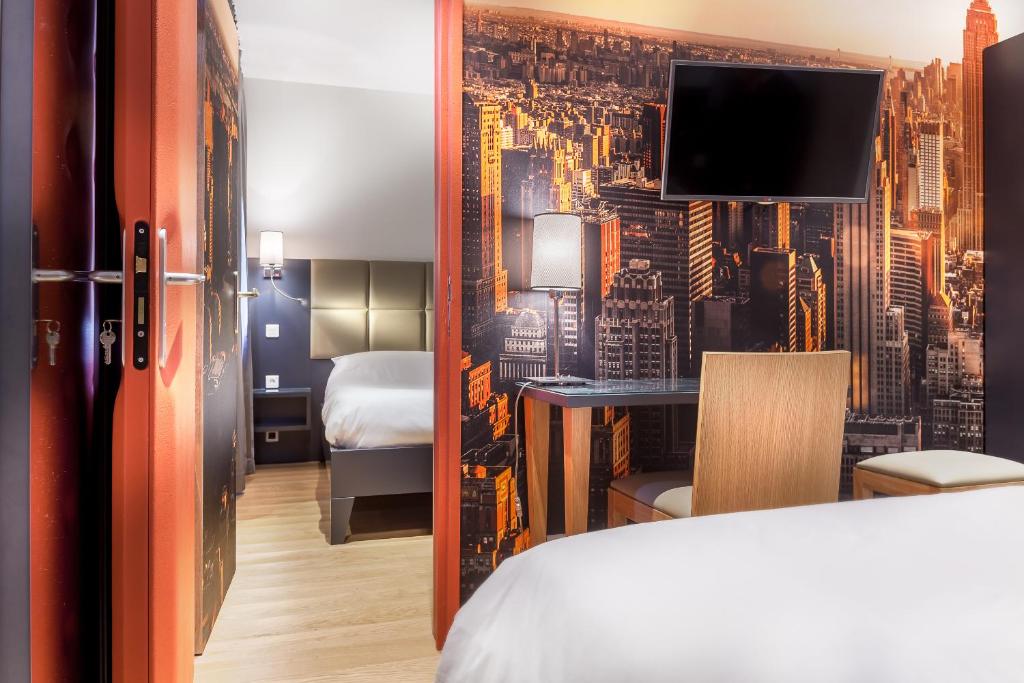 a hotel room with a bed and a bedroom with a wall mural at Hotel Jenner in Paris