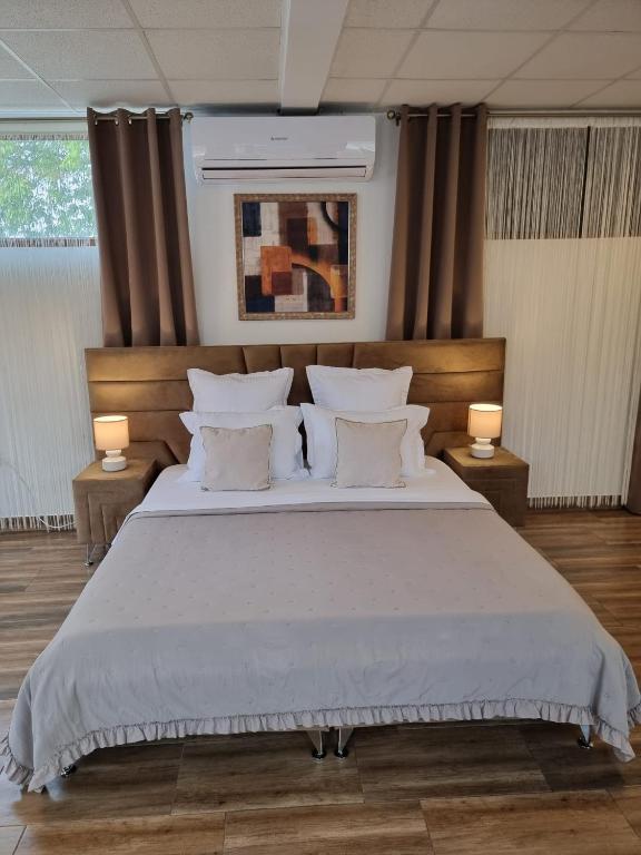 a bedroom with a large bed with two lamps at Studio Aurora Blue in Eforie Sud