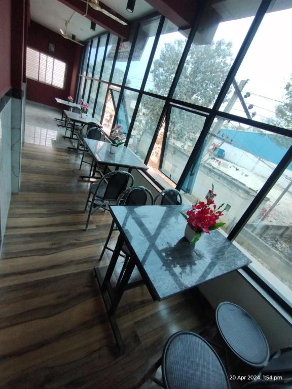a row of tables and chairs in a room with windows at GM Comforts -LODGE-CL-7 in Bangalore