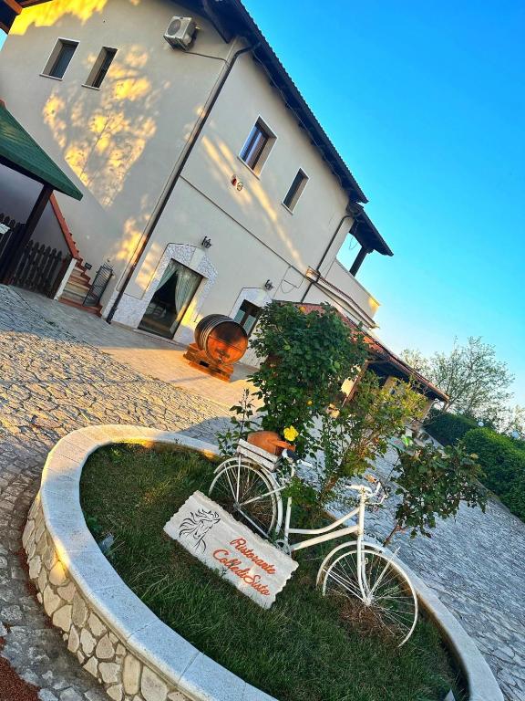 a white bike parked in front of a house at Colledisisto Guest House & Restaurant in Pomarico