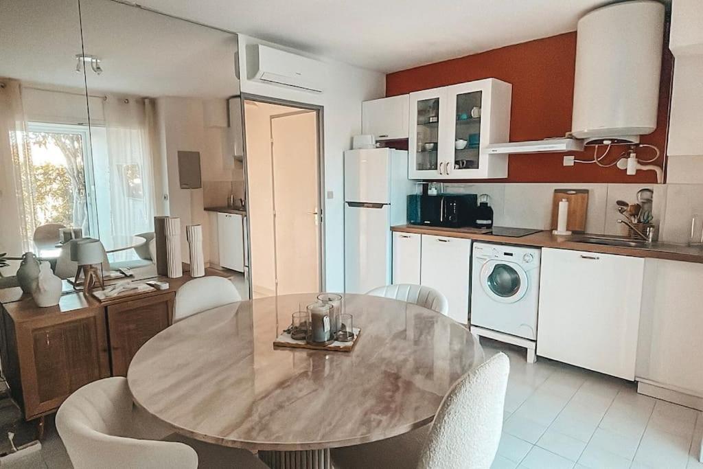 une cuisine avec une table et des chaises dans une pièce dans l'établissement Sunrise, au Cap d'Agde