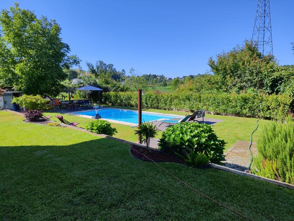 een achtertuin met een zwembad in een tuin bij CASA DA TIA ROSA in Fiscal