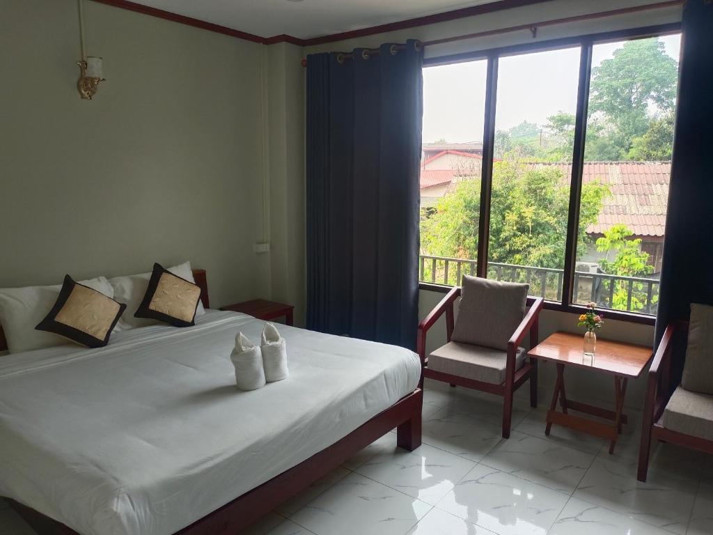 萬榮的住宿－Dokchampa Hotel，一间卧室设有一张床和一个大窗户
