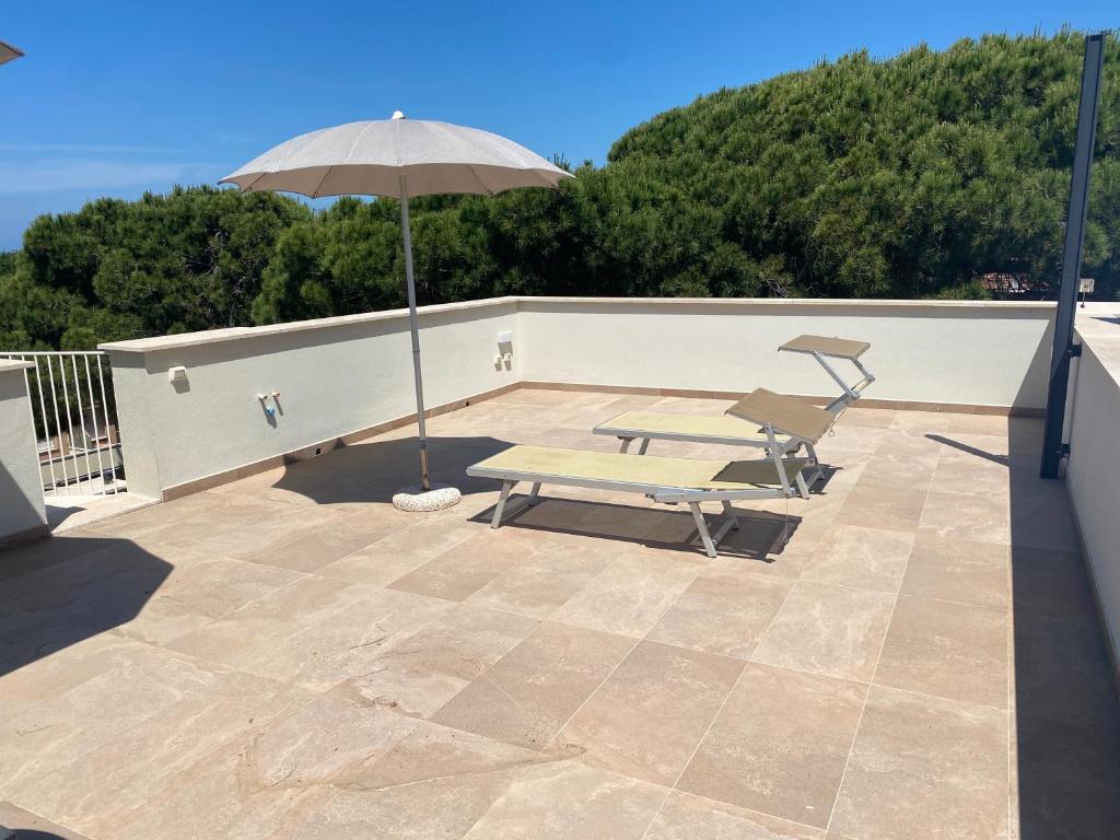 a patio with an umbrella and picnic tables on a roof at Venere Apartament in Tirrenia