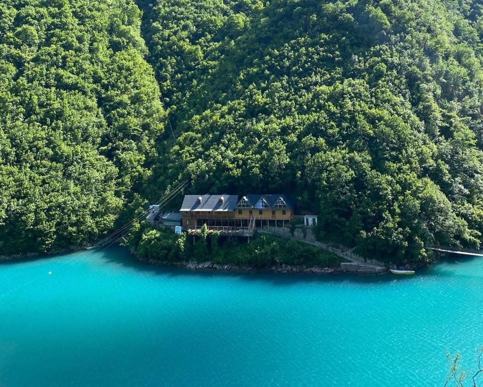 an aerial view of a house on an island in the water at Riverside Komani Lake in Koman