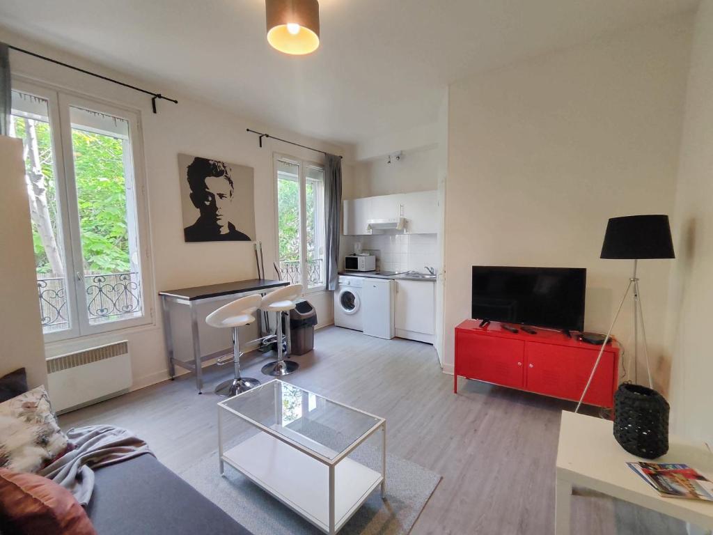 - un salon avec un canapé et une télévision dans l'établissement Charming Parisian studio!, à Paris