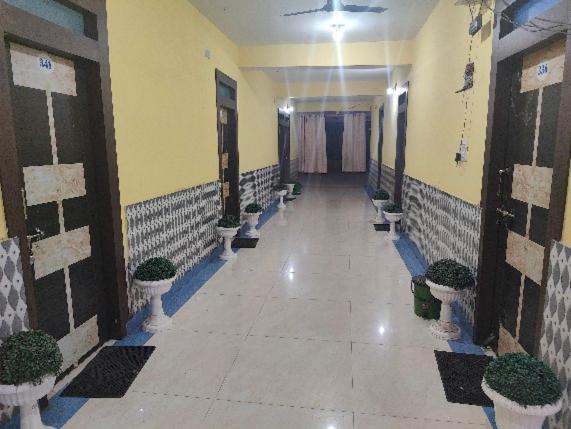 a hallway with potted plants in a building at Hotel Shobha in Rāmgarh