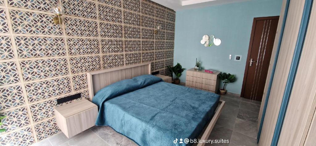 - une chambre avec un lit bleu et un mur en briques dans l'établissement B8 Luxury Suites- NEW just 2 mins from the beach, à San Pawl il-Baħar