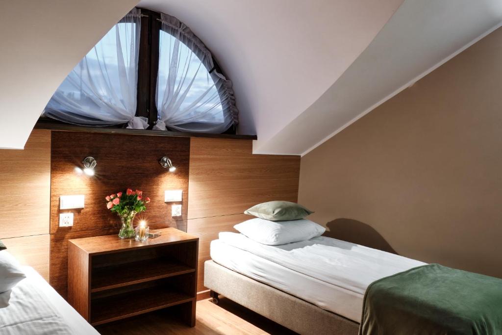 Oborniki ŚląskieにあるRestauracja Perłaのベッドルーム1室(ベッド2台、窓付)