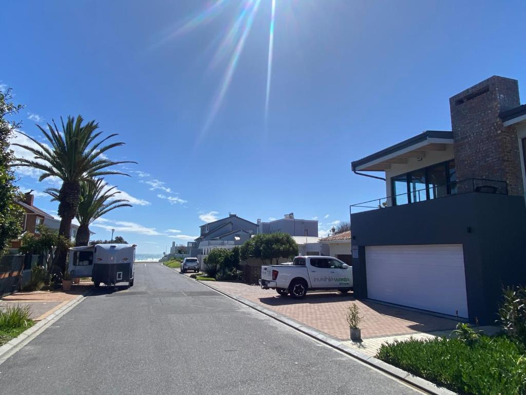 eine Straße, in der Fahrzeuge an der Seite eines Hauses geparkt sind in der Unterkunft SeaBreeze Guest Suite in Kapstadt