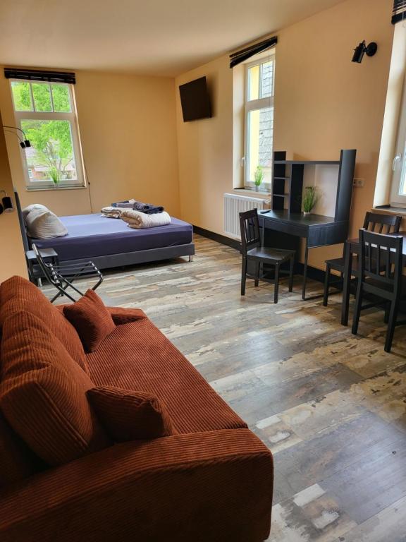 - un salon avec un lit, une table et des chaises dans l'établissement Hotel & Ferienpark Fleether Mühle, à Mirow