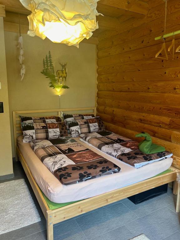 a bed in a room with a wooden wall at BnB Blockhausfeeling in Walenstadtberg