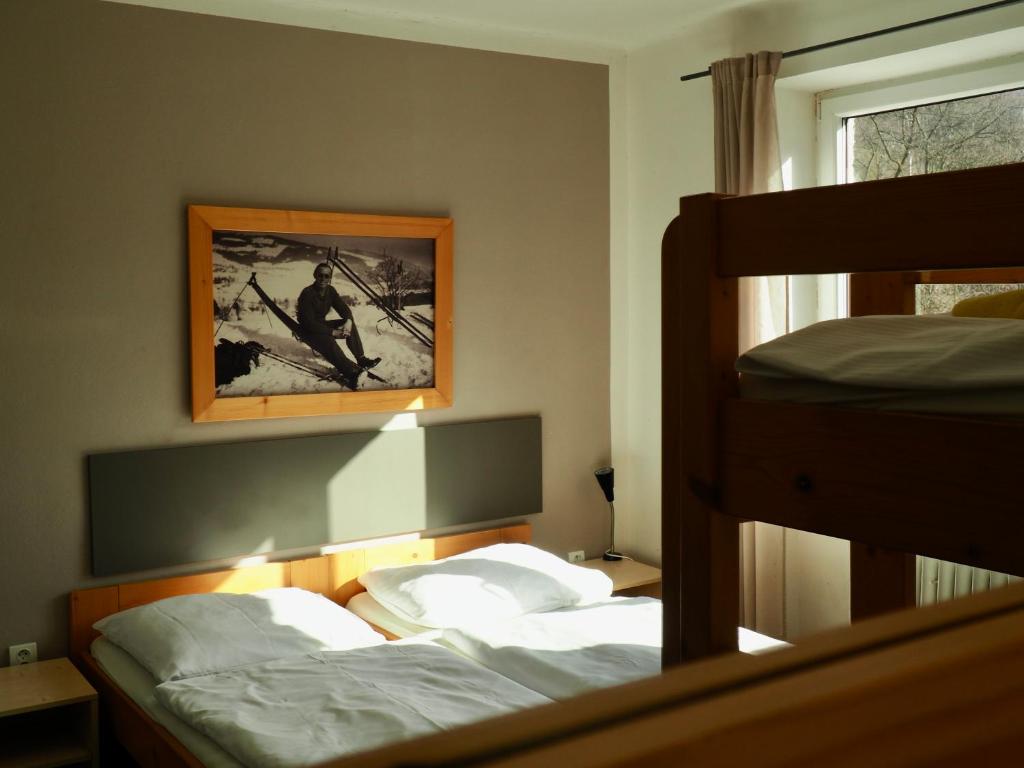 sypialnia z 2 łóżkami piętrowymi i zdjęciem na ścianie w obiekcie Penzion Kouty w mieście Loučná nad Desnou