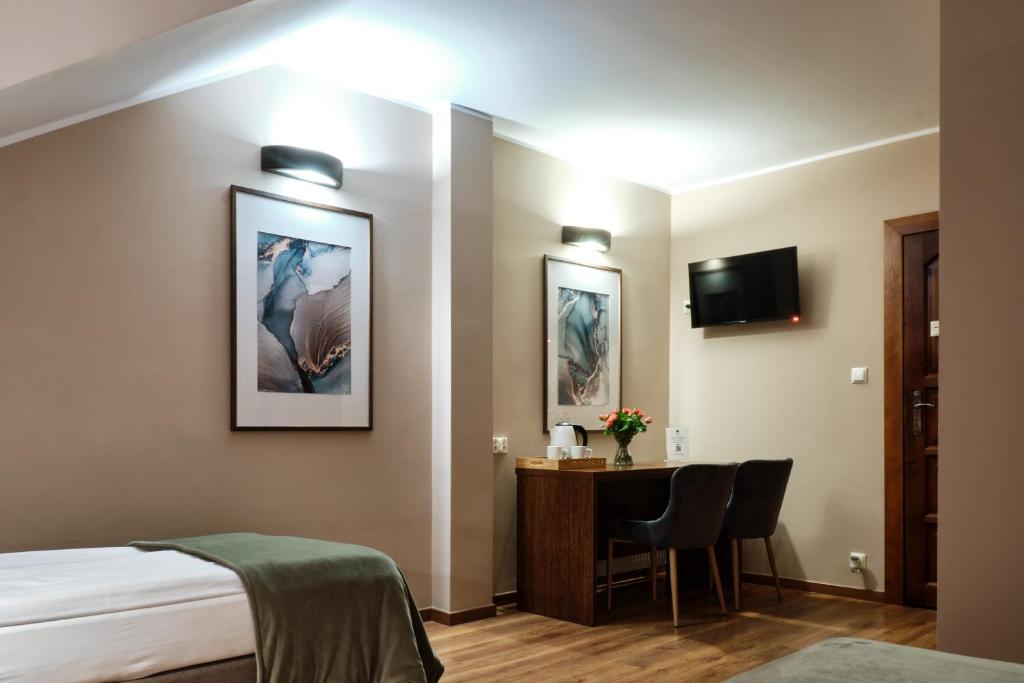 Pokój hotelowy z łóżkiem, biurkiem i telewizorem w obiekcie Restauracja Perła w mieście Oborniki Śląskie