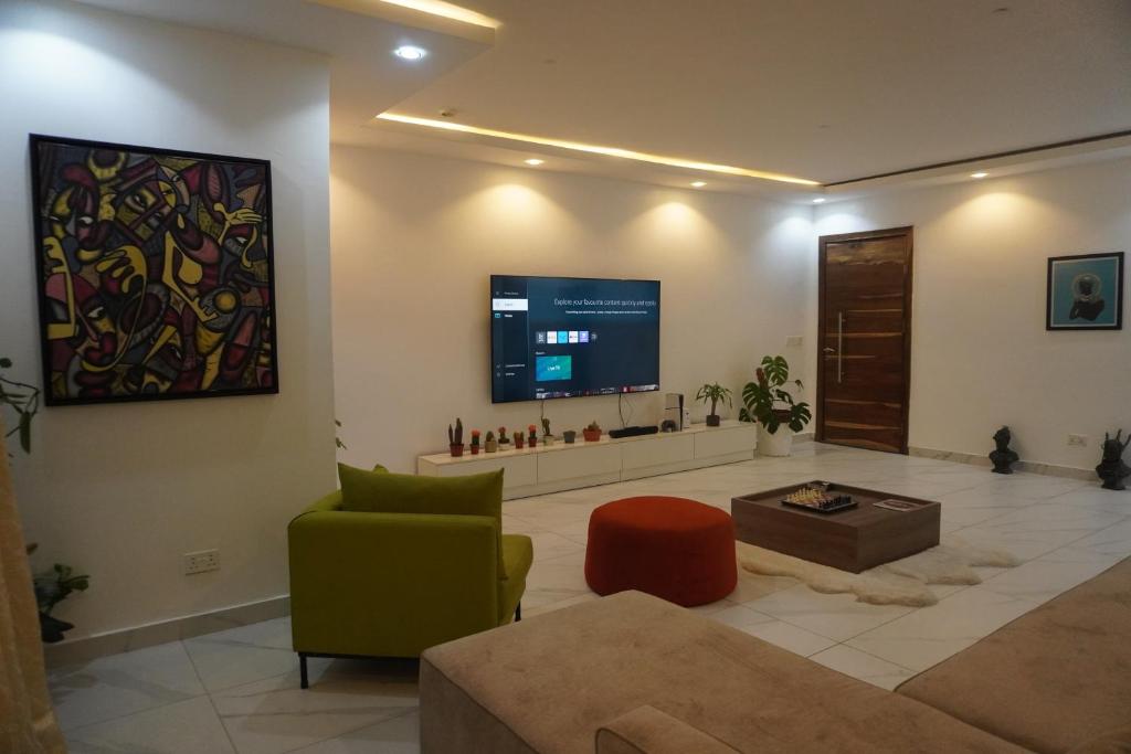 een woonkamer met een tv aan de muur bij TodaStays Luxury Apartments in Lekki Phase 1