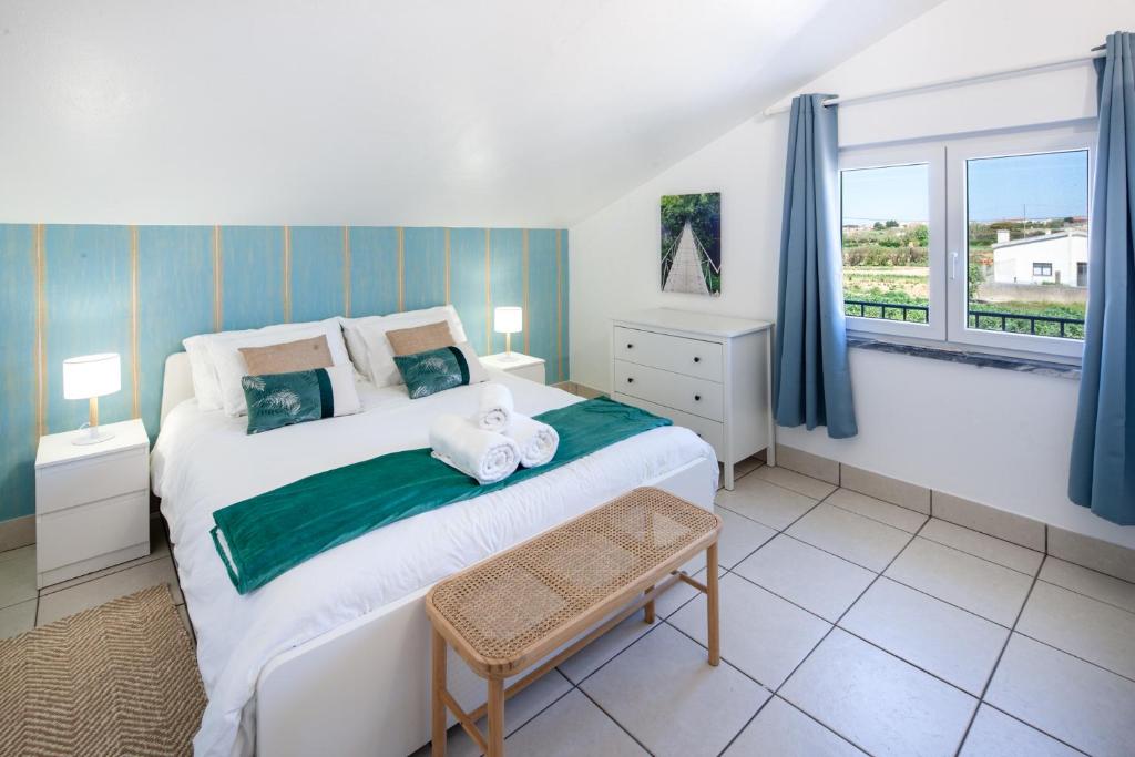 Un dormitorio con una cama grande y una ventana en Silvercoast Apartments - swimming pool & jacuzzi, en Atouguia da Baleia