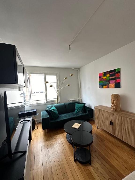 un salon avec un canapé vert et une table dans l'établissement Appartement 2 pièces lumineux, à Saint-Mandé