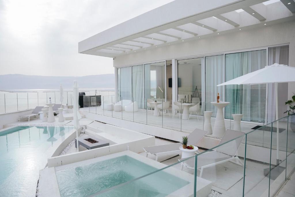 a house with a swimming pool and a living room at Lake of Dreams - מתחם מהמם עם יחידות נופש עם בריכות פרטיות מול ים המלח in Neve Zohar