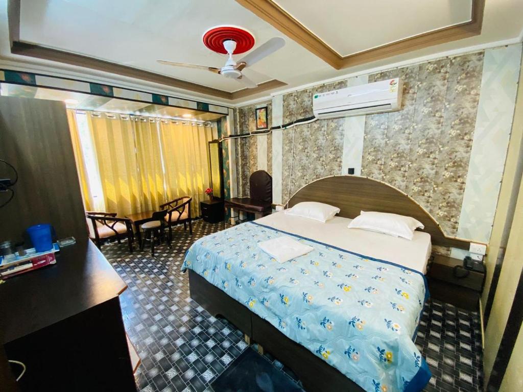 um quarto de hotel com uma cama e uma secretária e um quarto em Hotel Regard em Varanasi