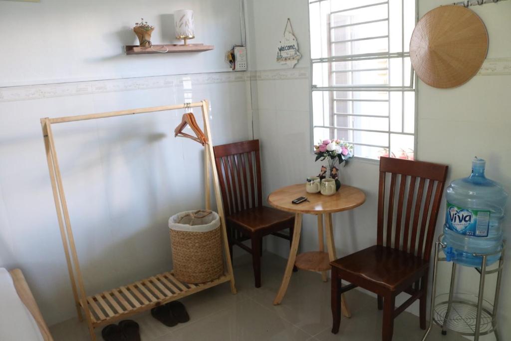 um quarto com duas cadeiras, uma mesa e uma janela em 79/10 Tran Phu House em Can Tho