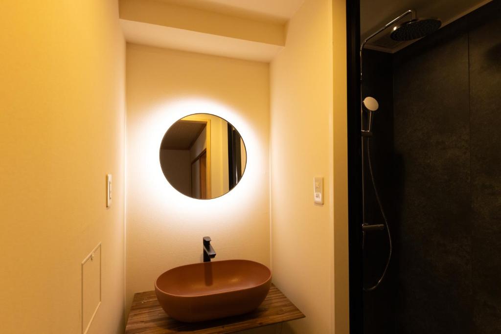 a bathroom with a wooden sink and a mirror at Ryokan Asakusa Shigetsu in Tokyo