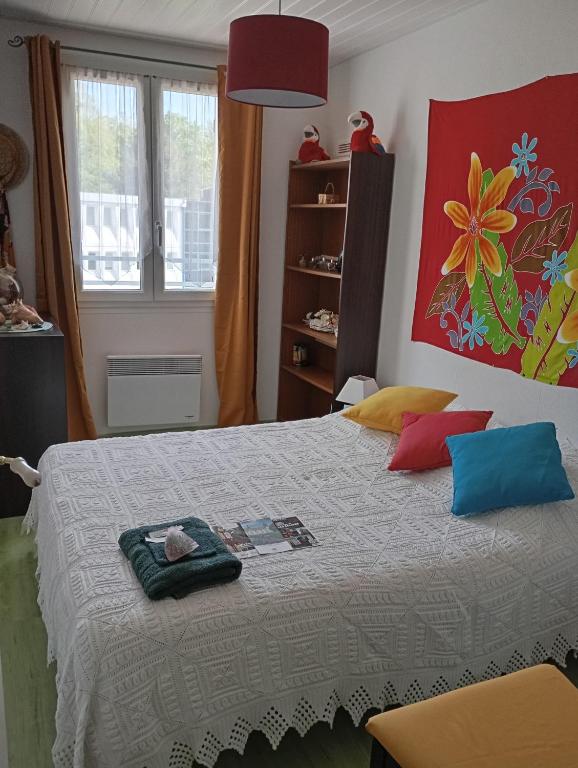 a bedroom with a large bed with colorful pillows at la maison rose 2 chambres a louer avec lits 2 personnes in Nevers