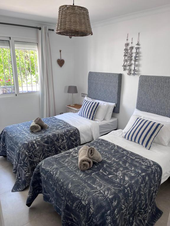 a bedroom with two beds with towels on them at Villa Tomillo in Málaga