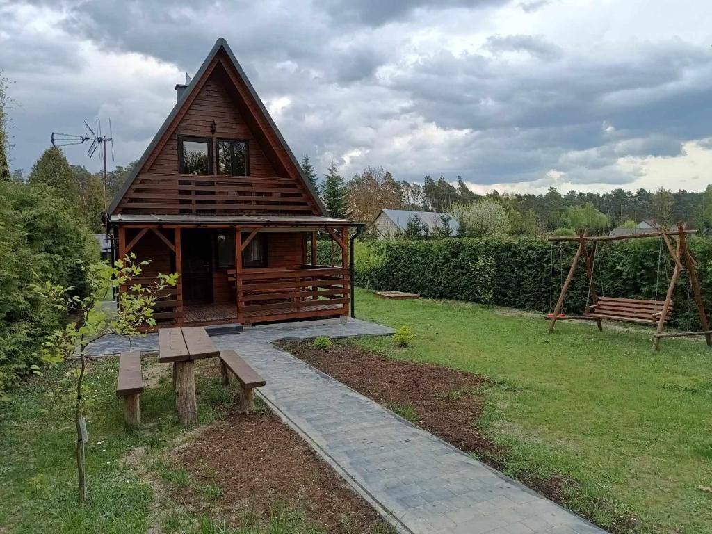 a small cabin with a bench in a yard at Jaś Roztocze in Nielisz