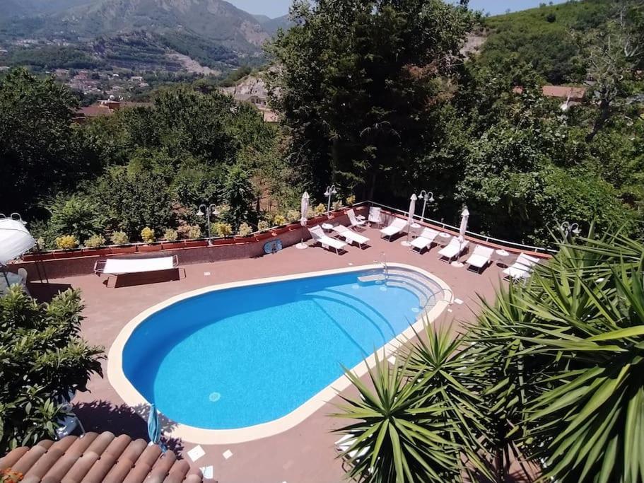 uma grande piscina com espreguiçadeiras e um resort em Villa Elvira em Pellezzano