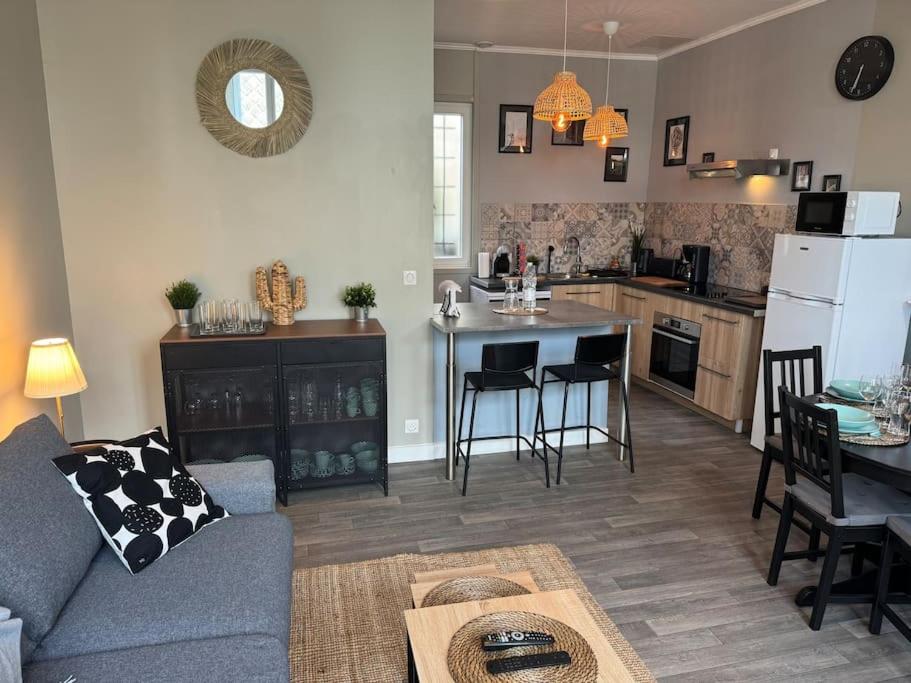 un soggiorno e una cucina con un divano e un tavolo di Belle maison médocaine a Saint-Julien-Beychevelle