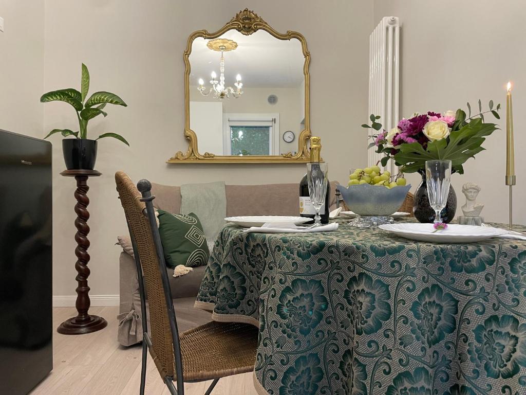 a table with a vase of flowers and a mirror at La Perla di Marina in Mestre