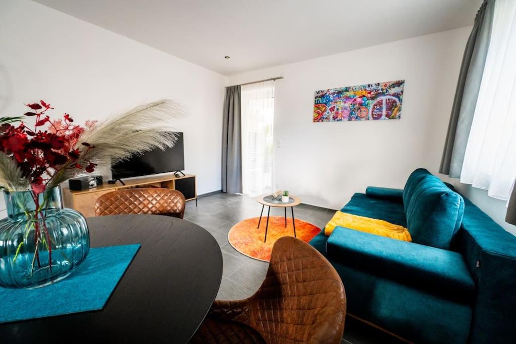 - un salon avec un canapé bleu et une table dans l'établissement Schicke Wohnung in Seenähe!, 