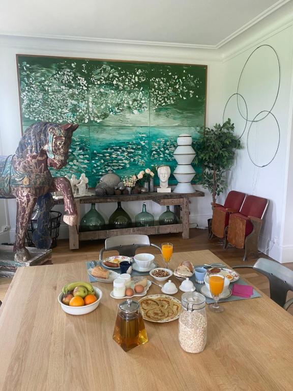 a dining room table with food on it with a painting at Domaine de la Besse in Célon