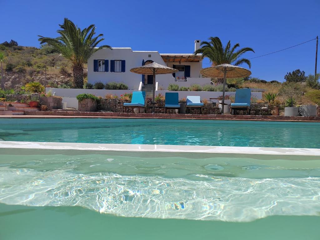 una piscina con sillas y una casa en el fondo en Oneiro glico, en Agia Marina Aegina