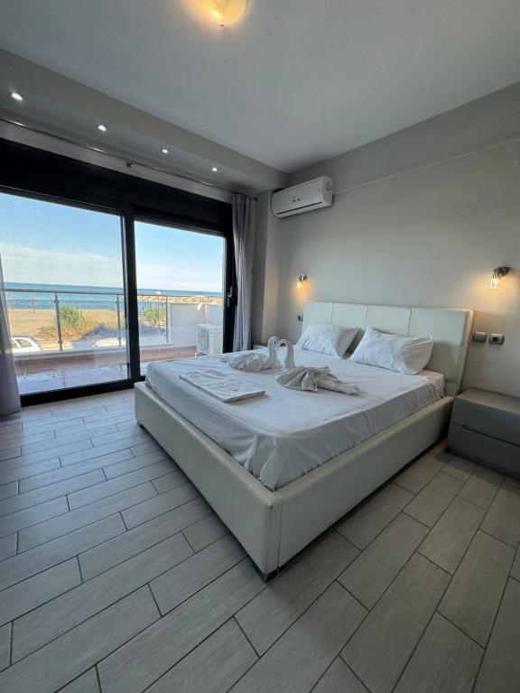 Schlafzimmer mit einem großen Bett und Meerblick in der Unterkunft Aqua Mare Luxury Apartments in Paralia Katerinis