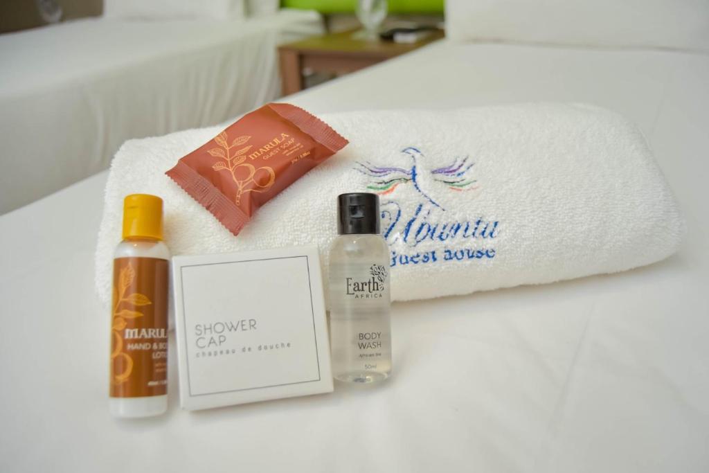 a bed with a towel and some products on it at Ubuntu Guesthouse in East London
