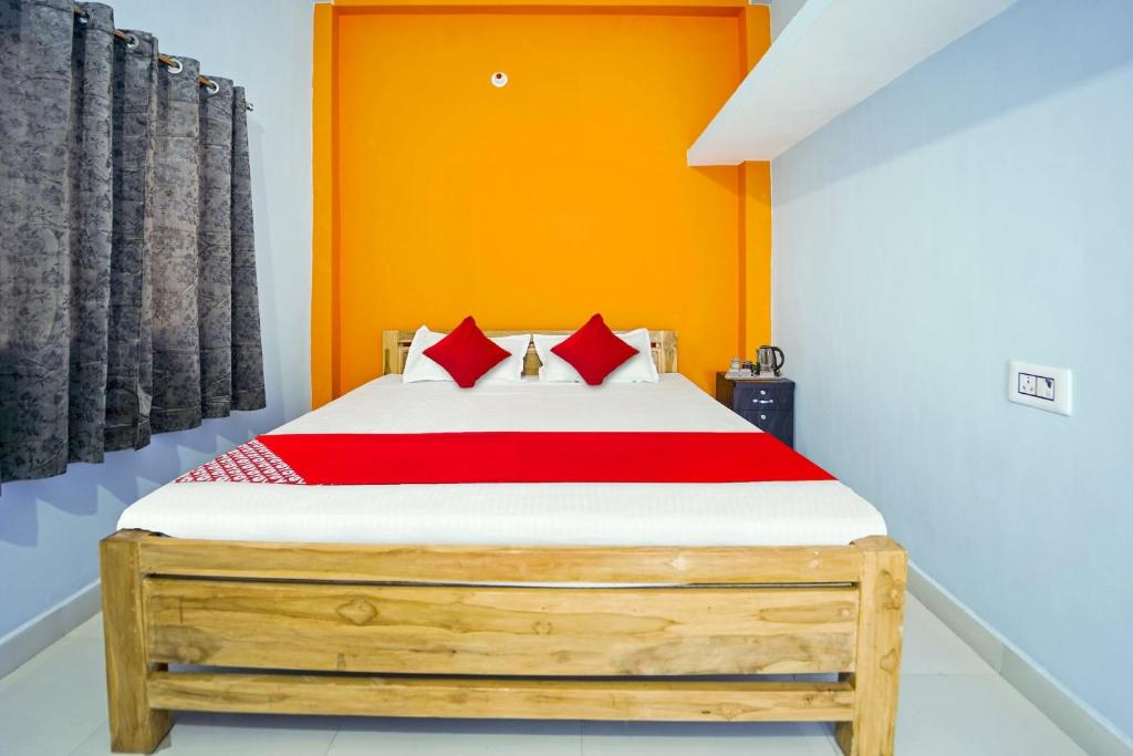 a bedroom with a wooden bed with red pillows at Flagship Youngsky in Gulzārbāgh
