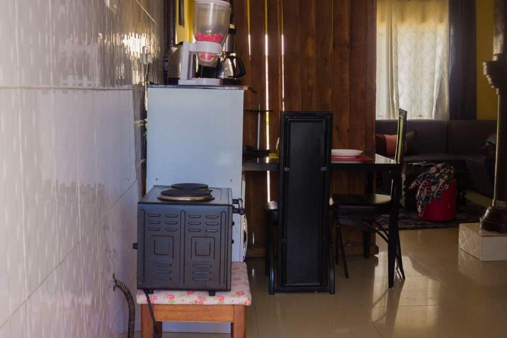 a kitchen with a stove and a refrigerator and a table at Itawa Apartments in Ndola