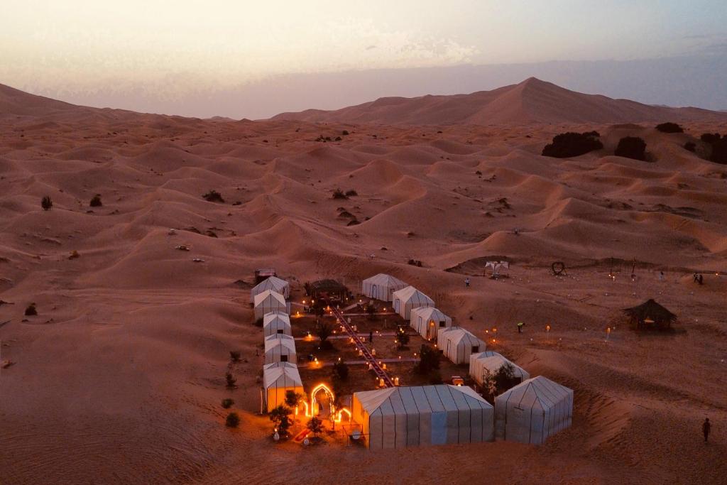 - une vue aérienne sur un désert avec des tentes dans le sable dans l'établissement Sahara Dream luxury Camp, à Merzouga