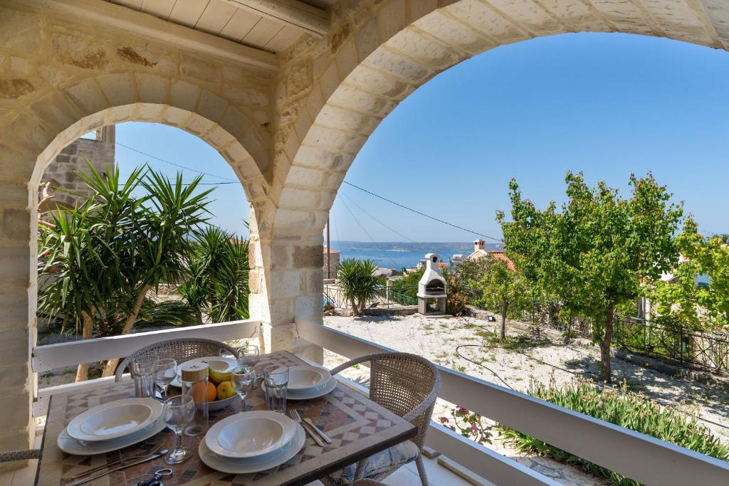 un tavolo su un balcone con vista sull'oceano di Villa Clio -St George Retreat BY APOKORONAS VILLAS a Kókkinon Khoríon