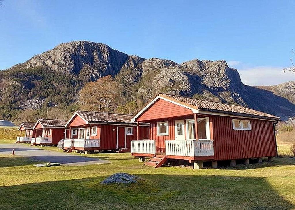 una fila de casas frente a una montaña en Wathne Camping en Bjørheimsbygda