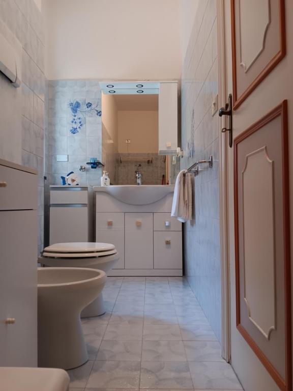 La salle de bains est pourvue de toilettes blanches et d'un lavabo. dans l'établissement Altamarea, à Gênes