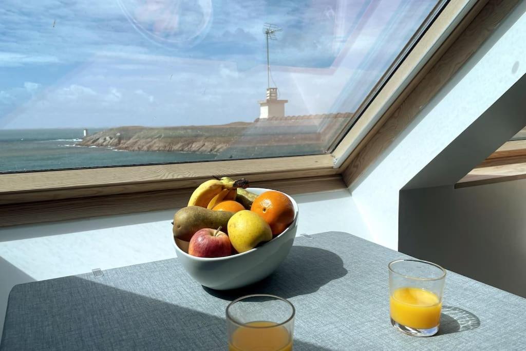 eine Schale mit Obst auf einem Tisch vor einem Fenster in der Unterkunft Kermorvan - pleine vue mer- parking et wifi - départ pour les îles in Le Conquet