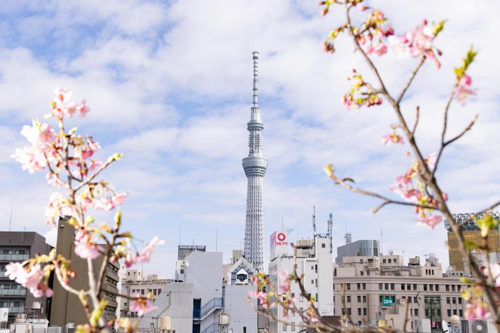 a view of the tokyo tower withakura trees in the foreground at Ryokan Asakusa Shigetsu in Tokyo