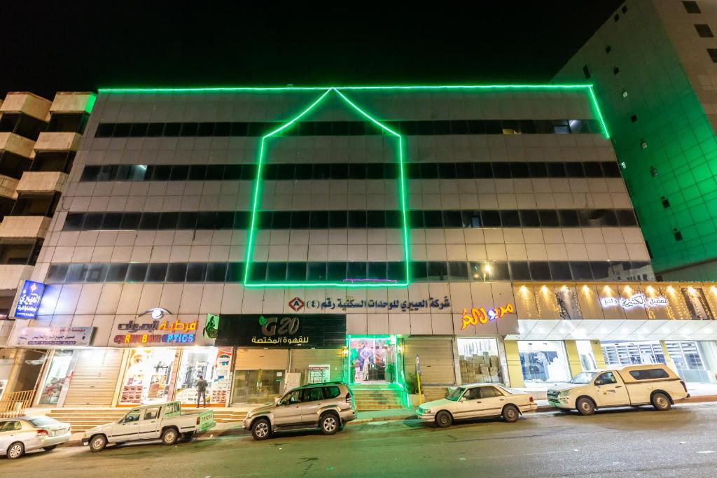 een gebouw met een groene pijl erop bij العييري للوحدات السكنية المفروشة الباحة 4 in Al Baha