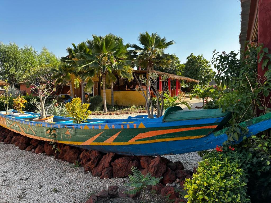 duża drewniana łódź siedząca na boku domu w obiekcie Mariama Lodge w mieście Mbodiène