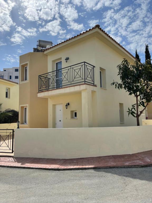 a large yellow house with a white fence at Casa Pernera in Protaras