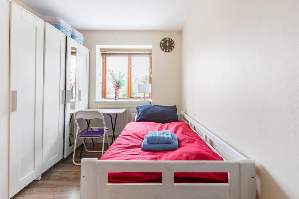 Un pequeño dormitorio con una cama roja en una habitación en Great Commute 20 mins from London Bridge and Gatwick Airport at Orpington, en Farnborough