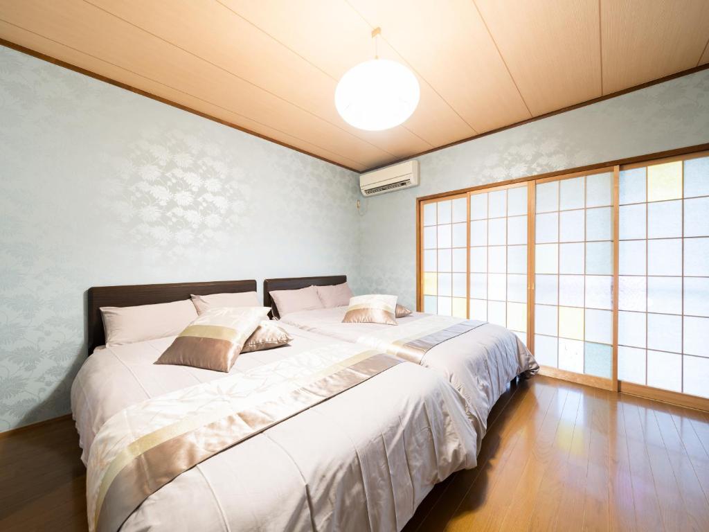 1 dormitorio con 1 cama grande con sábanas blancas en Shinjuku/Okubo sta, 3 min walk/switch/board game/65㎡２LDK, en Tokio